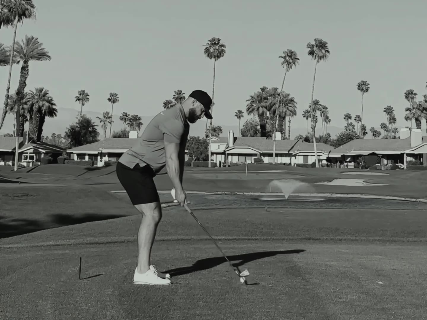 Golfer practising a swing at a driving range