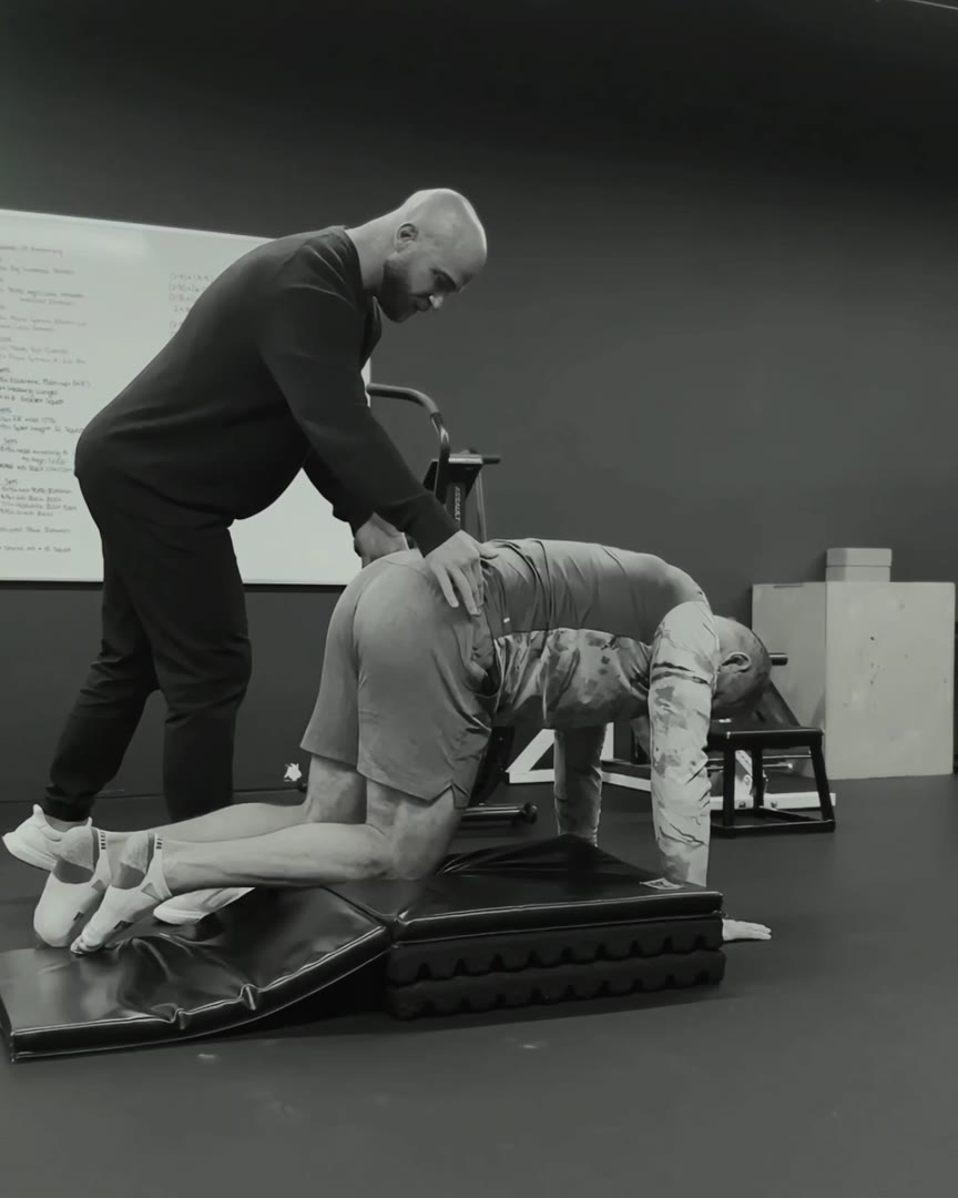 A Bridge coach providing individual movement guidance during a floor exercise